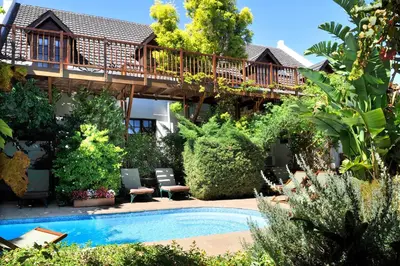 a house with a deck and a swimming pool at Gable Manor by Neighbourgood in Franschhoek