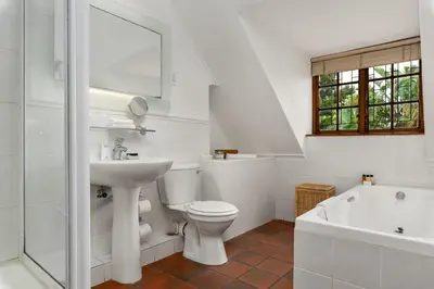 a bathroom with a toilet and a sink and a tub at Gable Manor by Neighbourgood in Franschhoek