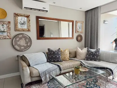 a living room with a couch and a glass table at Instellies Self Catering Apartment in Stellenbosch