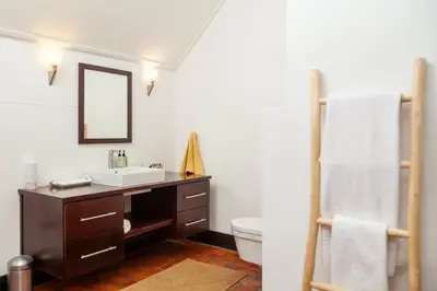 a bathroom with a sink and a toilet and a mirror at Manor at Longridge in Helderberg