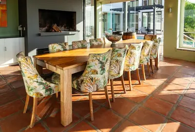 a dining room with a wooden table and chairs at Manor at Longridge in Helderberg