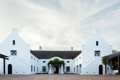 a white building with a black roof at Manor at Longridge in Helderberg