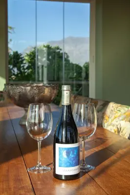 a bottle of wine and two wine glasses on a table at Manor at Longridge in Helderberg