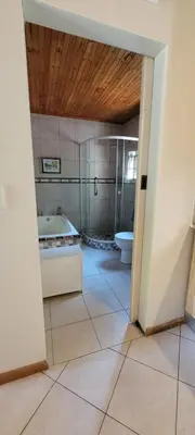 a bathroom with a tub and a sink and a toilet at Clarents Cottage in Somerset West