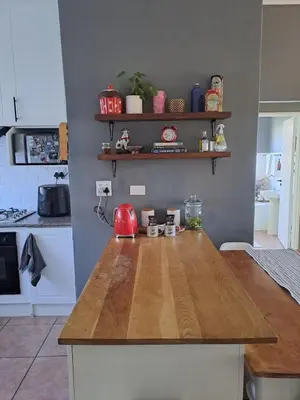 a kitchen with a wooden counter top in a kitchen at Central 3rd Floor Durbanville Apartment in Durbanville