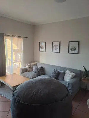 a living room with a couch and a table at Central 3rd Floor Durbanville Apartment in Durbanville