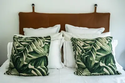 a group of pillows sitting on top of a bed at Private Garden Flat in Die Boord with Secure Parking in Stellenbosch