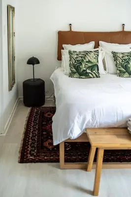 a bedroom with a bed with a table next to it at Private Garden Flat in Die Boord with Secure Parking in Stellenbosch