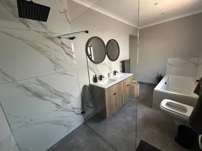 a bathroom with a sink and a mirror at A home away from home near the beach in Strand
