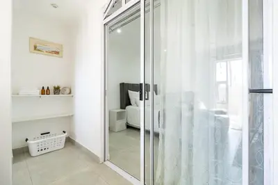 a glass shower in a bathroom with a bedroom at Flatlet on Circle in Cape Town