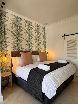 a bedroom with a large bed with two pillows at The Boutique Suites by Beach Collection Winelands in Cape Town