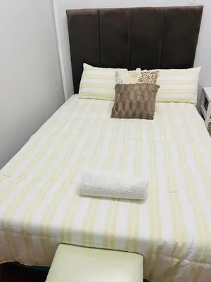 a bed with a striped mattress with a pillow on it at claremont AN guesthouse in Cape Town