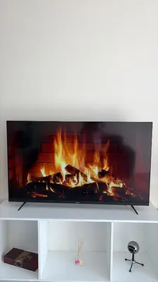 a fire in a fireplace on a white shelf at Delightful Retreat in Parklands,Cape Farms,Cape Town in Cape Town
