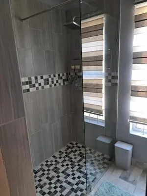 a bathroom with a shower with a glass door at The Pink Flamingo Self Catering Accommodation in Cape Town