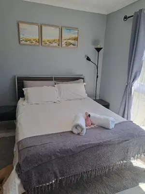 a baby doll laying on a bed in a bedroom at The Pink Flamingo Self Catering Accommodation in Cape Town