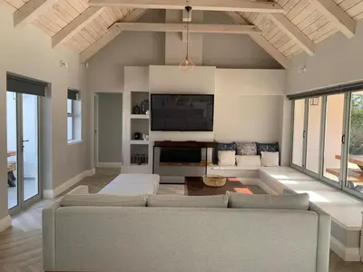 a living room with a couch and a tv at Taylah's Hideaway in Bettyʼs Bay