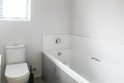 a bathroom with a toilet and a bath tub at Flat in Security Estate - Zomerwind Apartments in Oakdale