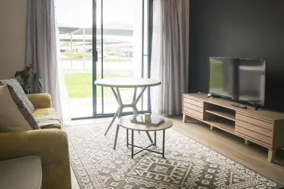 a living room with a tv and a table and a couch at Flat in Security Estate - Zomerwind Apartments in Oakdale