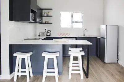 a kitchen with a counter and stools in it at Flat in Security Estate - Zomerwind Apartments in Oakdale