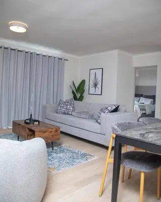 a living room with a couch and a table at Cape on Viola in Cape Town