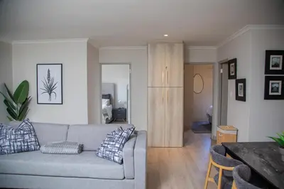 a living room with a couch and a table at Cape on Viola in Cape Town
