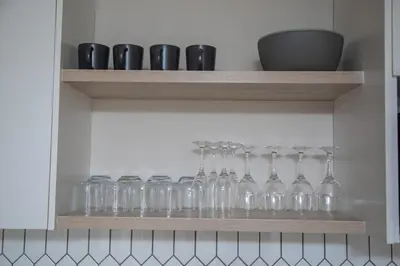 a row of glasses on a shelf in a kitchen at Cape on Viola in Cape Town