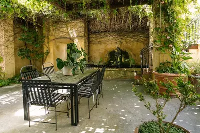 a patio with a table and chairs with plants at Auberge Burgundy Boutique Hotel & Spa in Hermanus