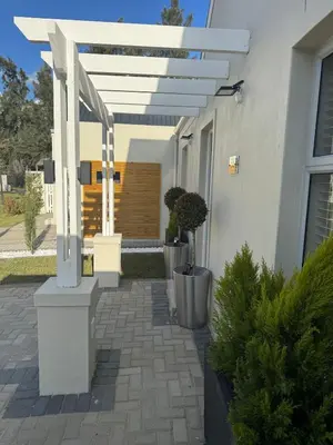 a white house with a patio with potted plants at Montblanc 3 Bed 3 Bath House in residential security Estate in Stellenbosch