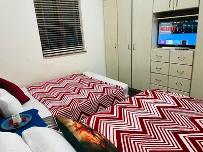 a living room with a couch and a tv at Annika`s dormitory in claremont in Cape Town