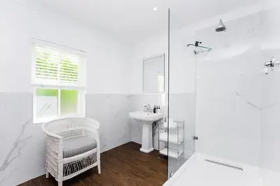a white bathroom with a sink and a shower at River Manor Boutique Hotel by The Living Journey Collection in Stellenbosch
