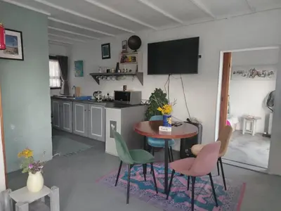 a kitchen with a table and chairs in a room at Cocos Island in Bettyʼs Bay