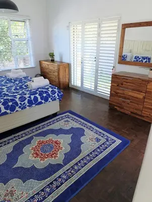 a bedroom with two beds and two rugs at Ascot manor in Cape Town