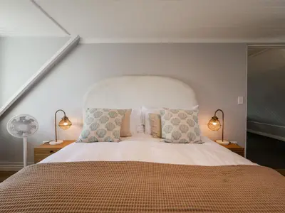 a bedroom with a large bed with two lamps at Salt & Butter in Hermanus