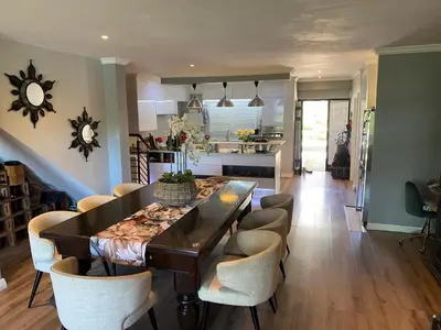a kitchen and dining room with a table and chairs at Luxury Lakeside Lodge at Jack Nicklaus Golf Estate in Simondium