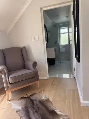 a living room with a couch and a walk in shower at 9 Charme in Stellenbosch