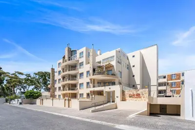 a large white apartment building on the side of a street at Coral Grove in Cape Town