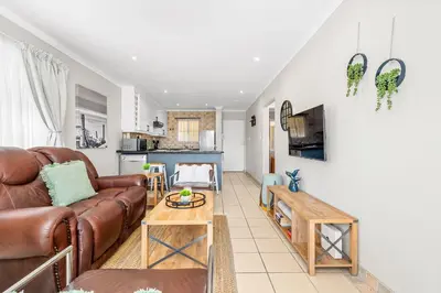 a living room with a couch and a table at Coral Grove in Cape Town