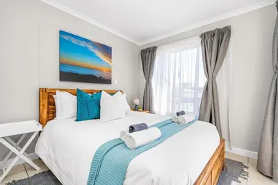 a bedroom with a large bed and a window at Coral Grove in Cape Town