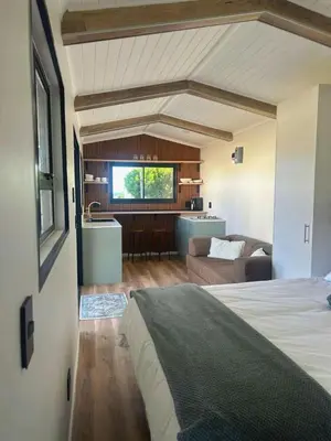 a bedroom with a bed and a living room at Logans place in Hermanus