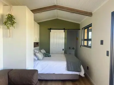 a bedroom with a large white bed in a room at Logans place in Hermanus