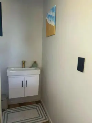 a bathroom with a white sink and a mirror at Logans place in Hermanus