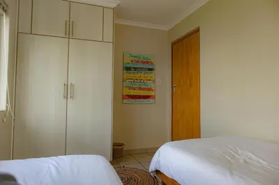 a bedroom with a bed and a closet and a door at Bona Vista in Pringle Bay
