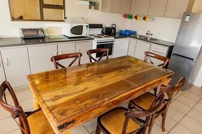 a kitchen with a wooden table and chairs at Bona Vista in Pringle Bay