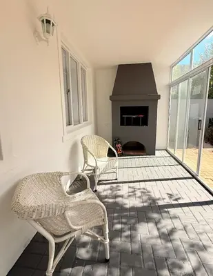 a living room with two chairs and a fireplace at Crescent House in Franschhoek