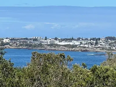 a view of a large body of water with buildings at Mountain View Voëlklip One Bedroom in Hermanus