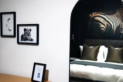a bedroom with a bed with two pictures on the wall at The Onyx Stellenbosch in Stellenbosch