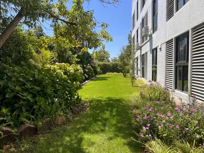 a garden with pink flowers next to a building at The Onyx Stellenbosch in Stellenbosch