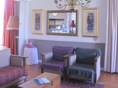 a living room with two chairs and a mirror at The Boston Guest House in Bellville