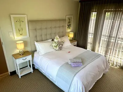 a bedroom with a large white bed with two lamps at Quiet Business Stay with Stunning Pool in Welgemoed