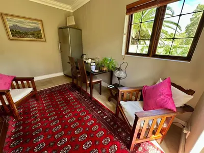 a living room with two chairs and a table at Quiet Business Stay with Stunning Pool in Welgemoed
